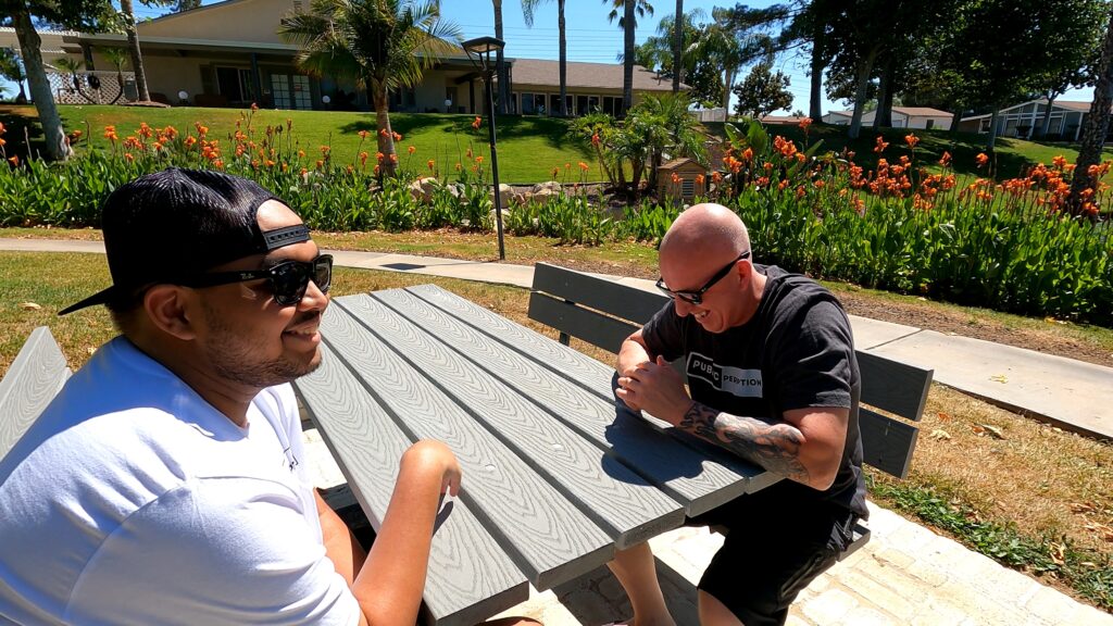 two public perception brand male models enjouying a conversation at a bench